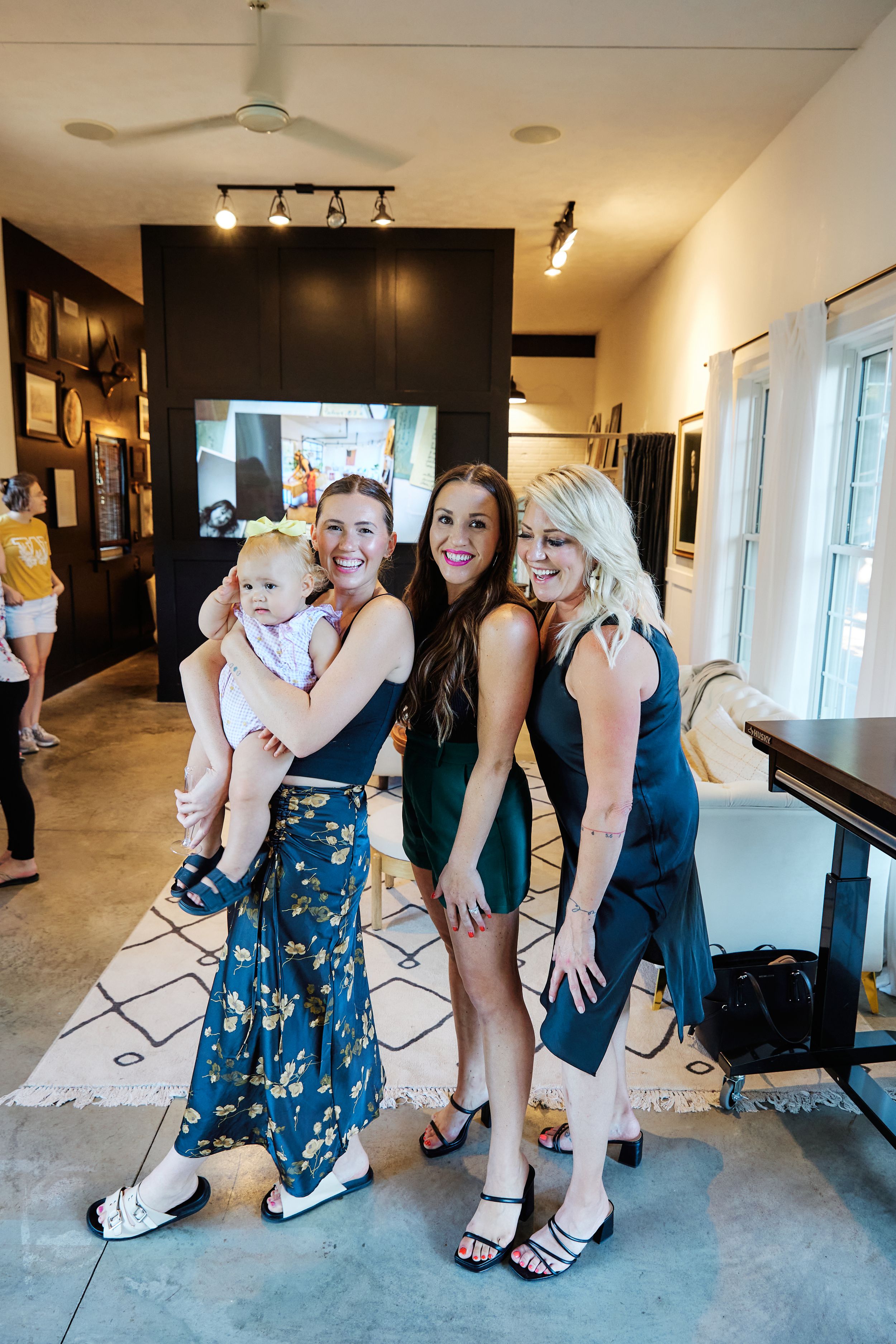 Group posing playfully in a modern studio space with concrete floors and white walls.