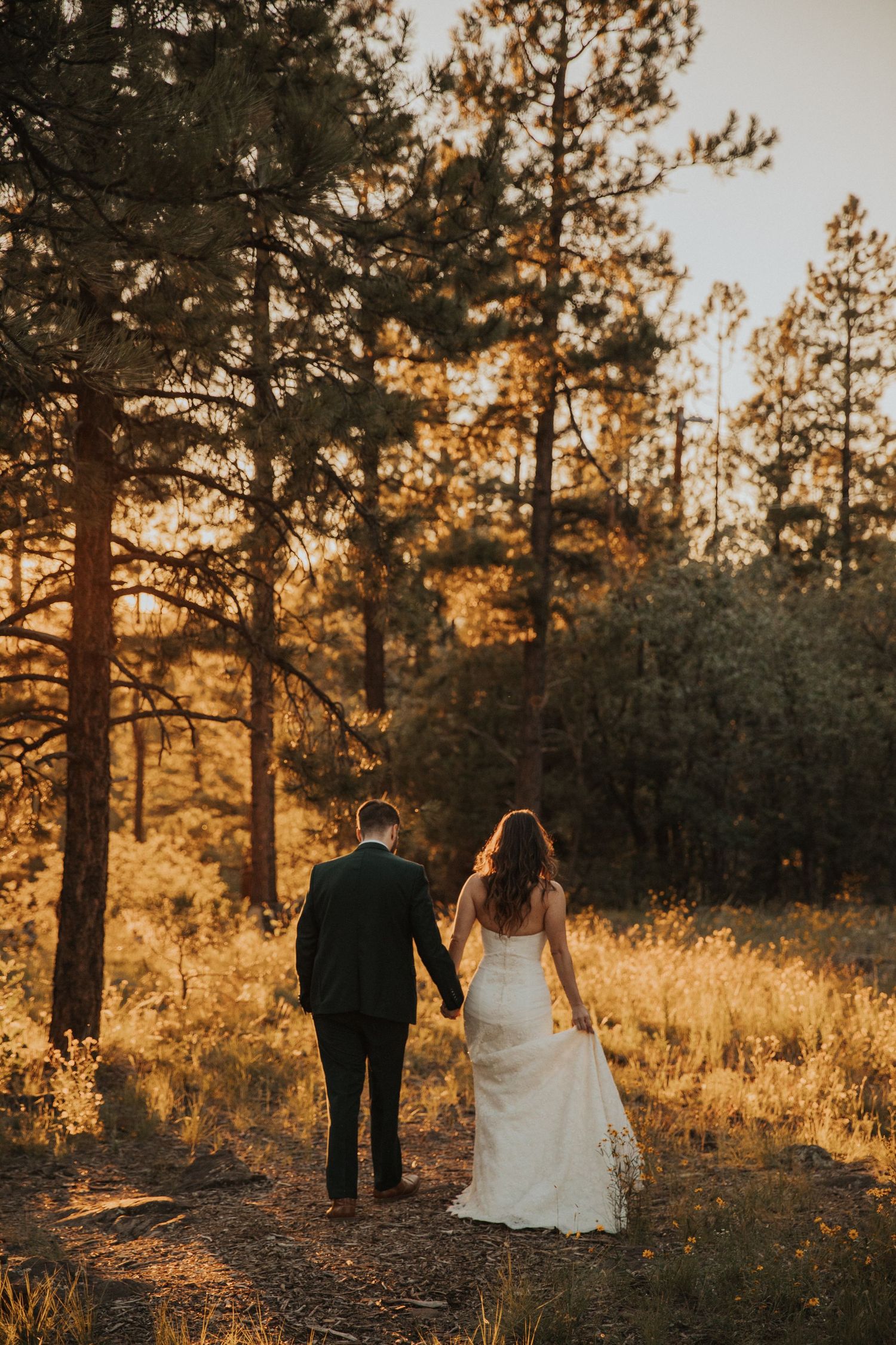 Couple waling through the trees in Flagstaff at sunset