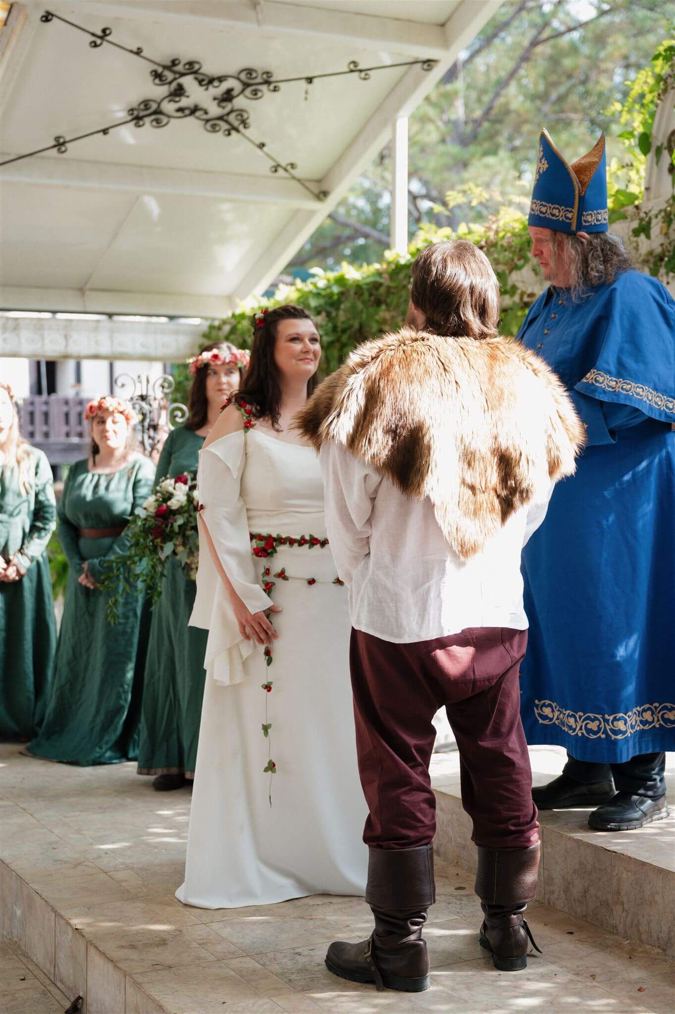 Medieval wedding ceremony with performers in period costumes and flowing gowns.