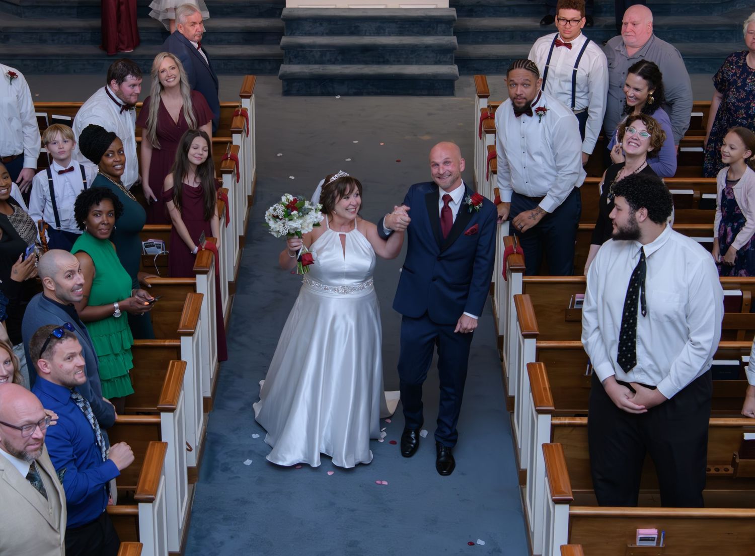 Wedding ceremony taking place in a traditional church with formal decorations.