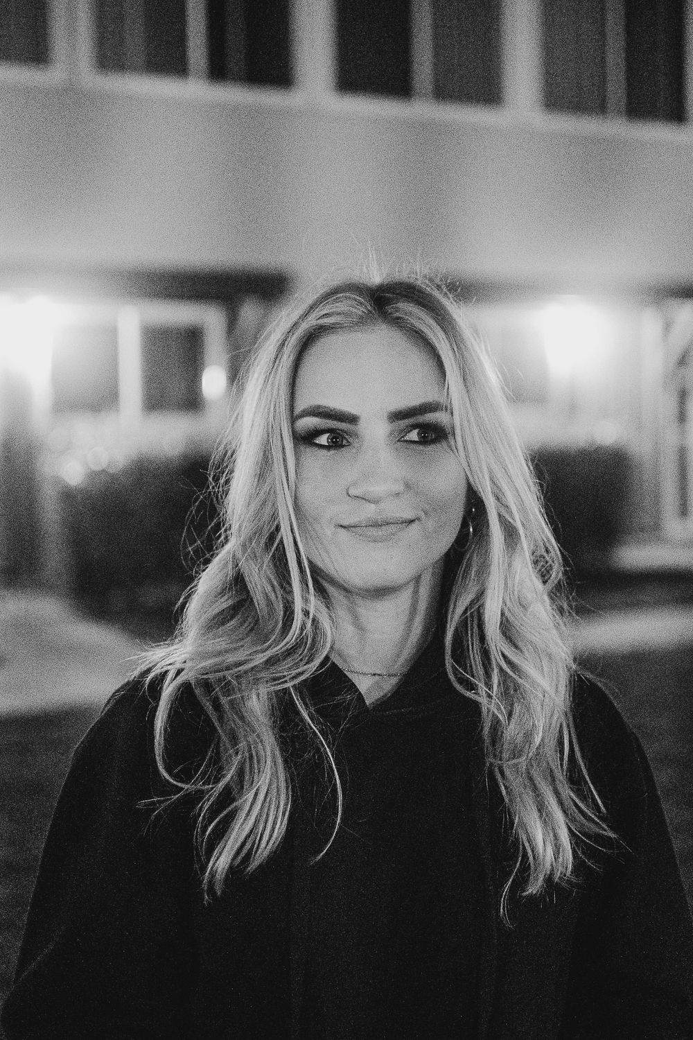 Black and white portrait showing a person with flowing blonde hair smiling.