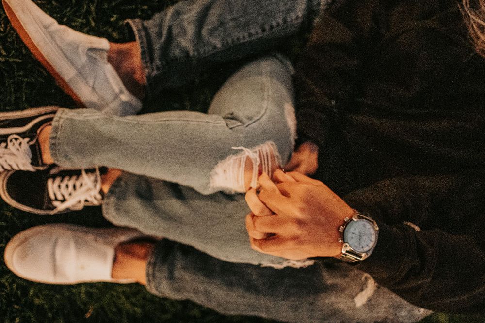 Casual shoes and distressed jeans detail shot in natural lighting.