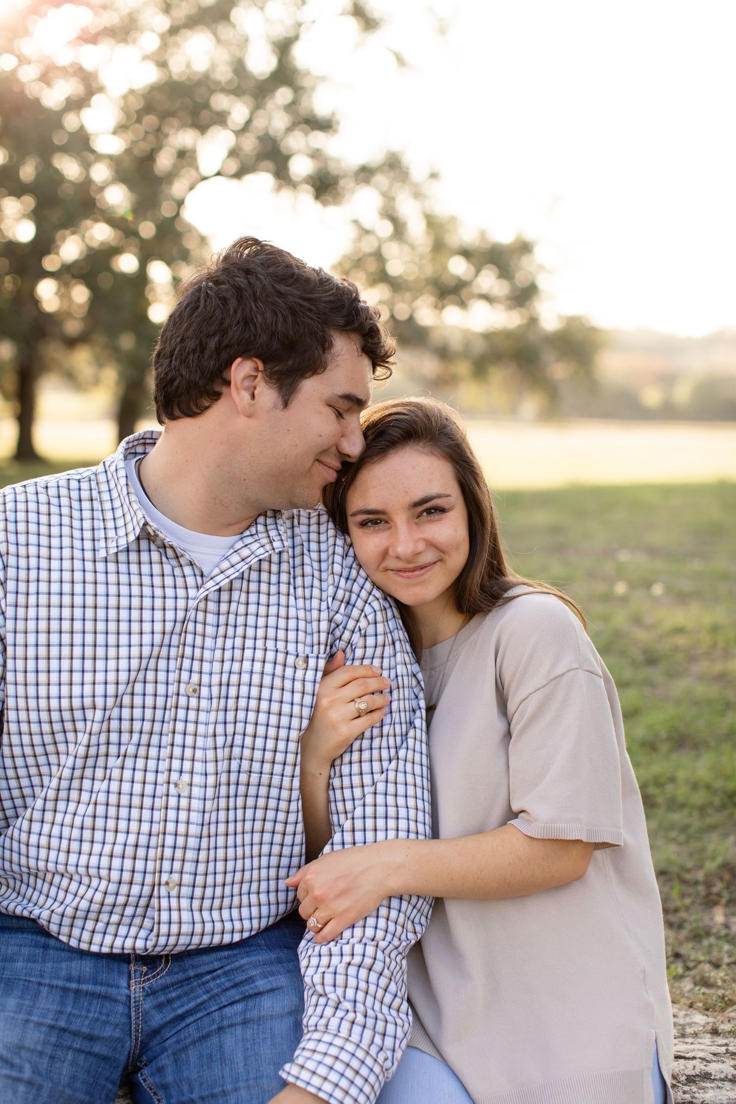 A sweet candid moment captured between two people in warm sunset lighting.