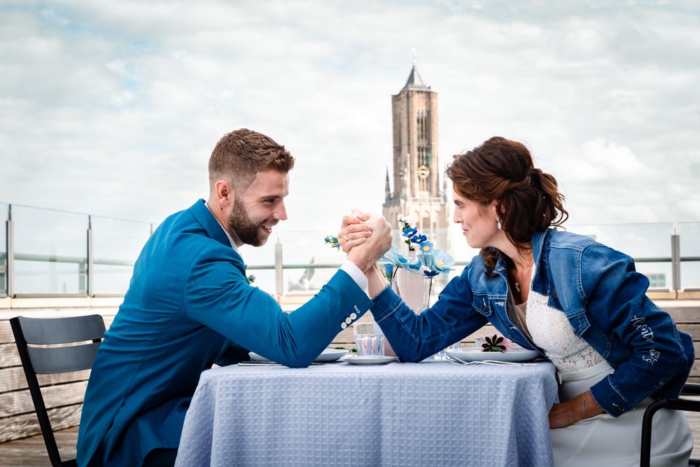 Speels bruidspaar aan tafel op het dakterras van Rozet – bruidsfotografie Arnhem