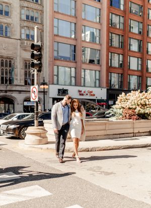 Stylish couple strolling together near traffic lights in a city setting.