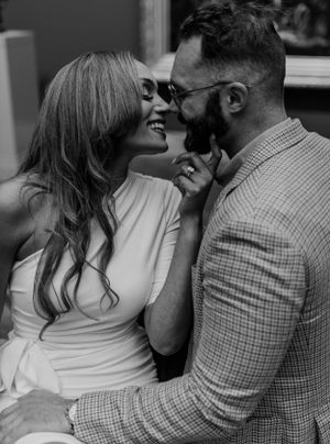 Black and white candid photo of couple laughing and embracing in casual attire.