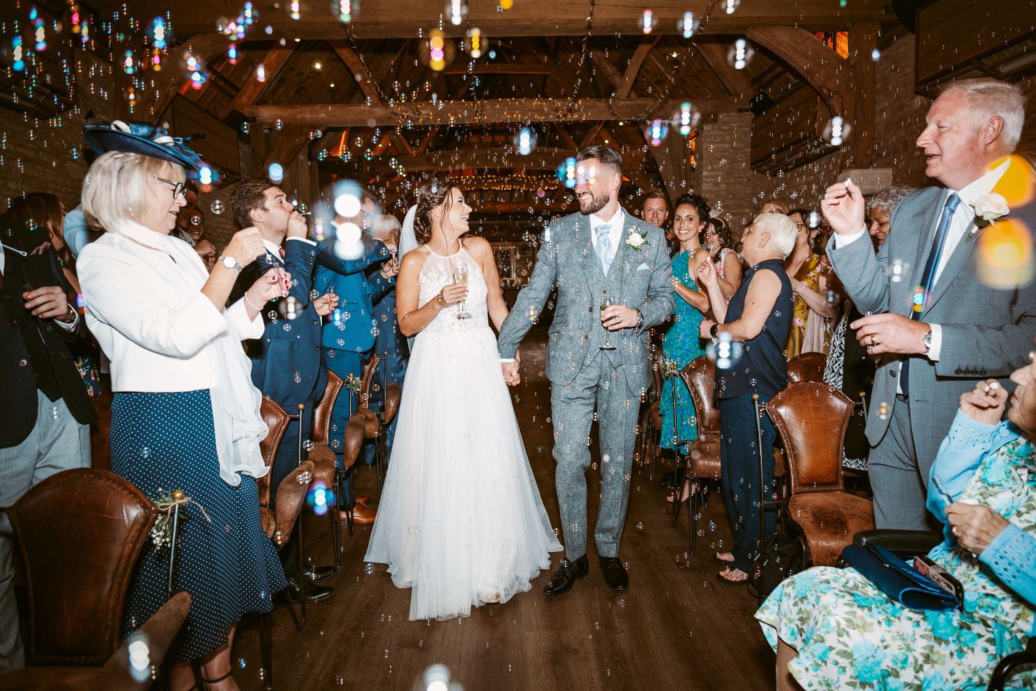 Wedding celebration with confetti flying through the air as guests cheer in a rustic indoor venue.