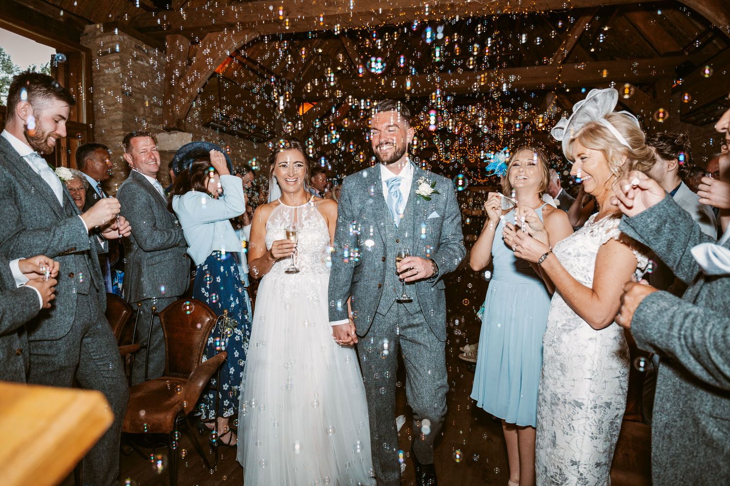 Guests celebrate with confetti during a joyous wedding reception in a rustic barn setting.
