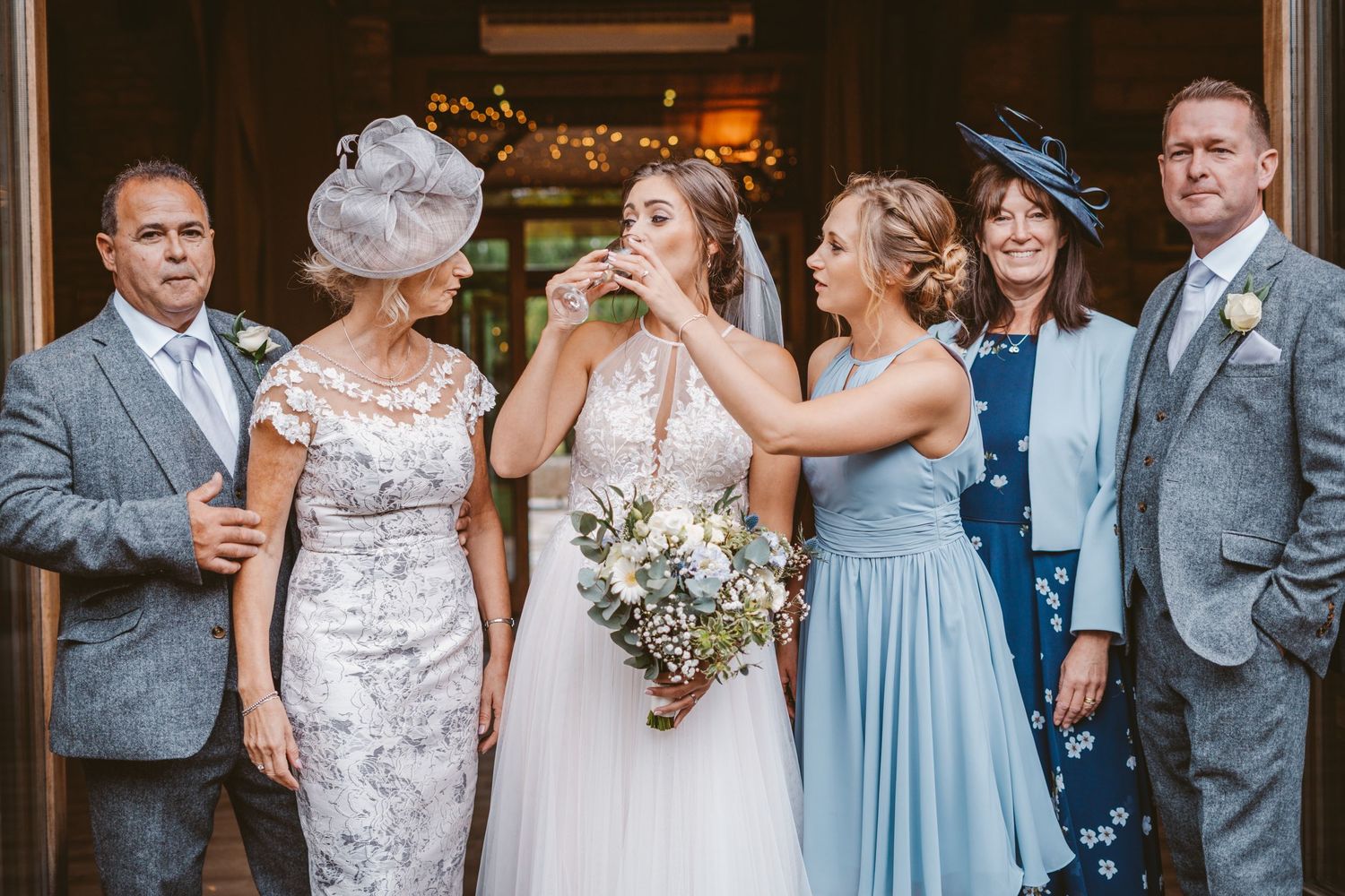 Candid moment of wedding party laughing and drinking champagne together.