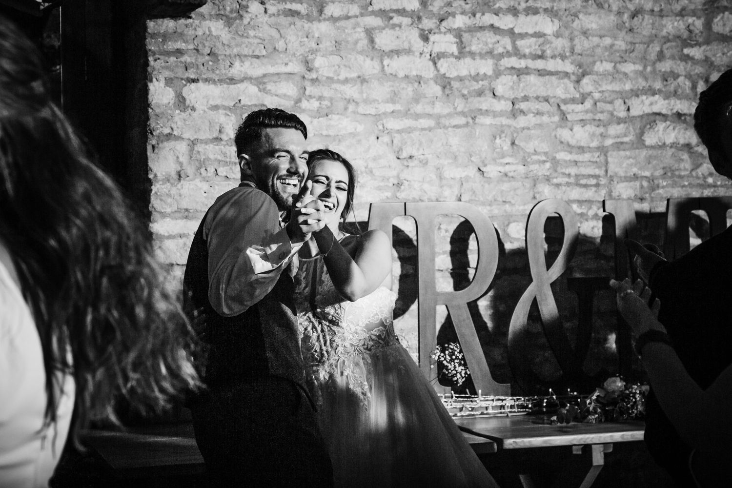 Intimate celebration moment in rustic brick venue with romantic lighting and decor.