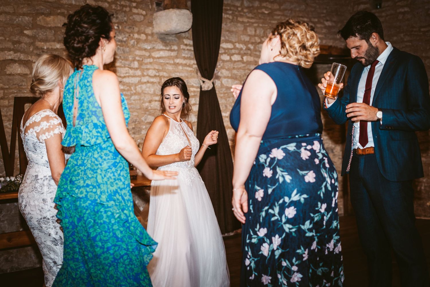 Wedding reception gathering in a rustic brick venue with guests in formal attire.