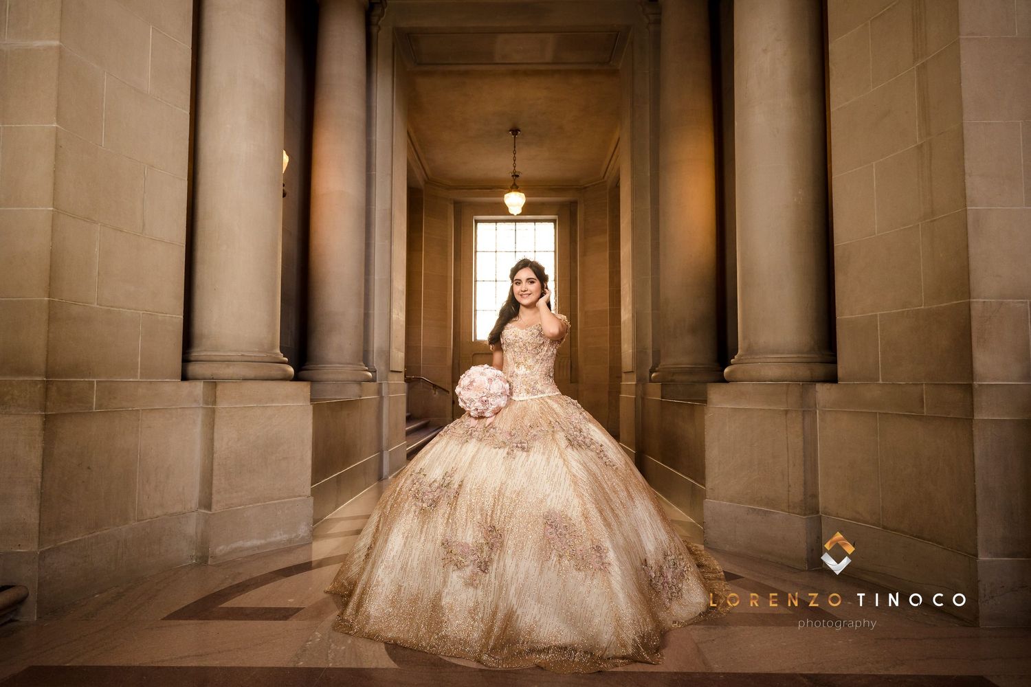 A dramatic portrait of a formal gown in a stone corridor with classic architectural elements.