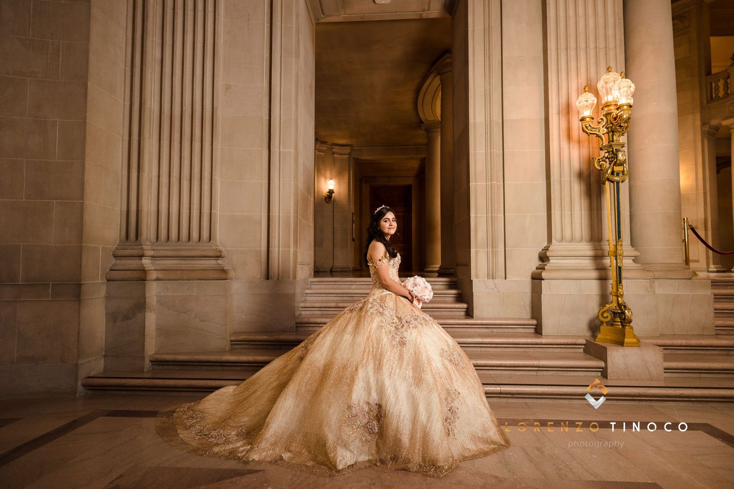 A beautiful ballgown captured on stone steps beside an elegant vintage lamp post.