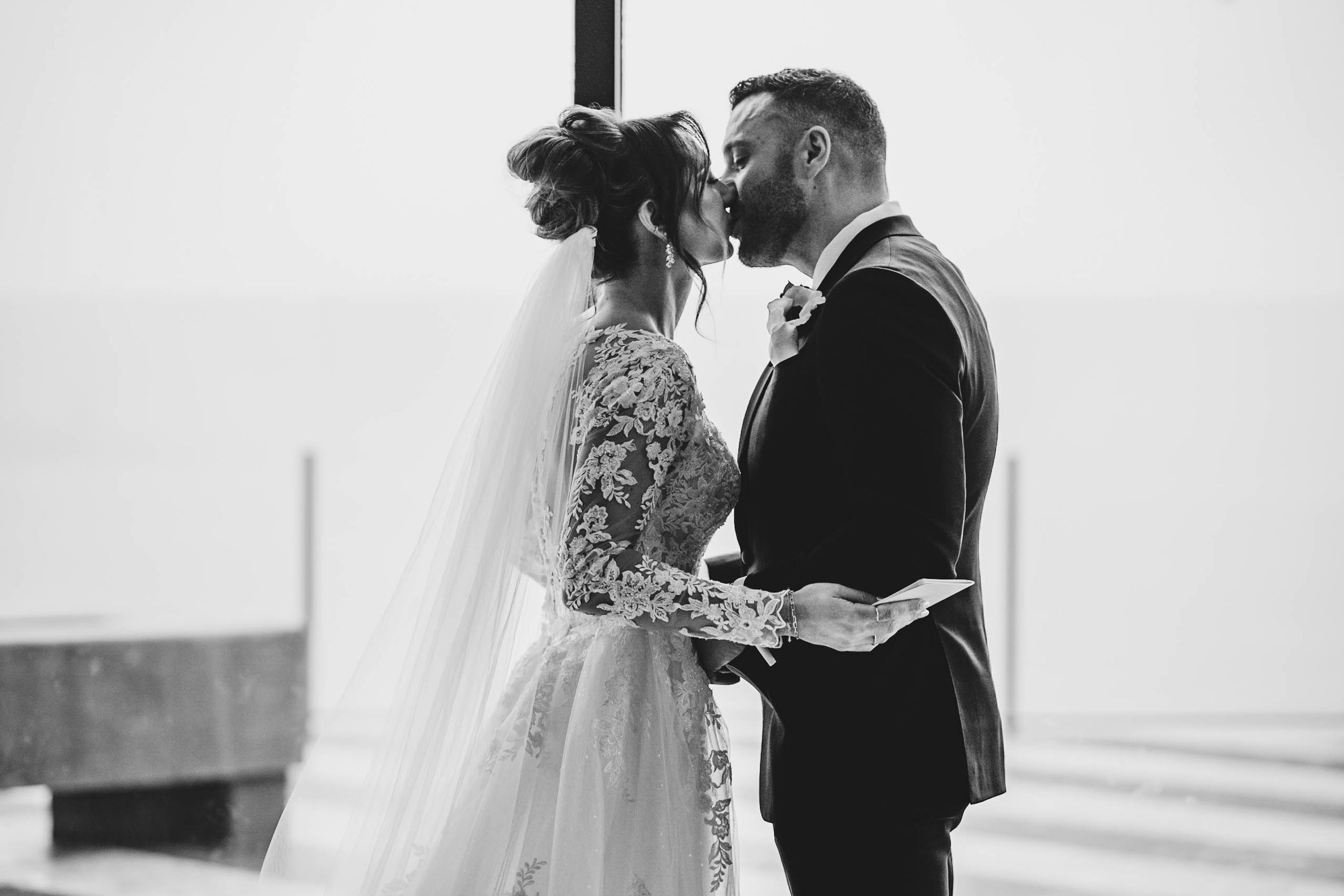 Tender moment between newlyweds during their first look in a bright indoor setting.