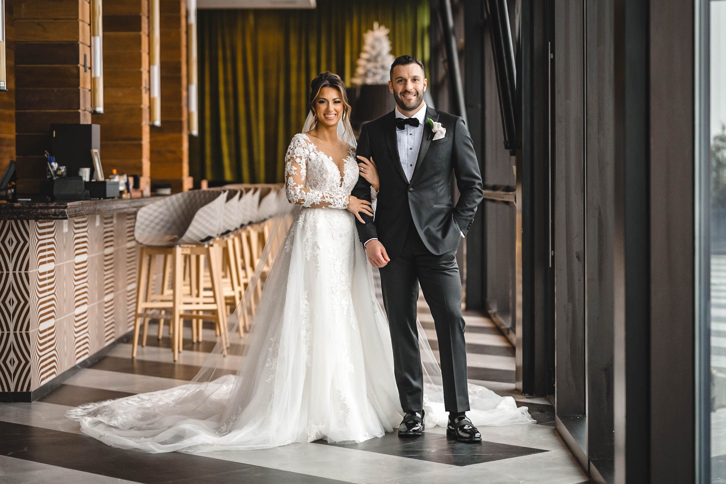Wedding couple's emotional reaction during first look in modern indoor venue.