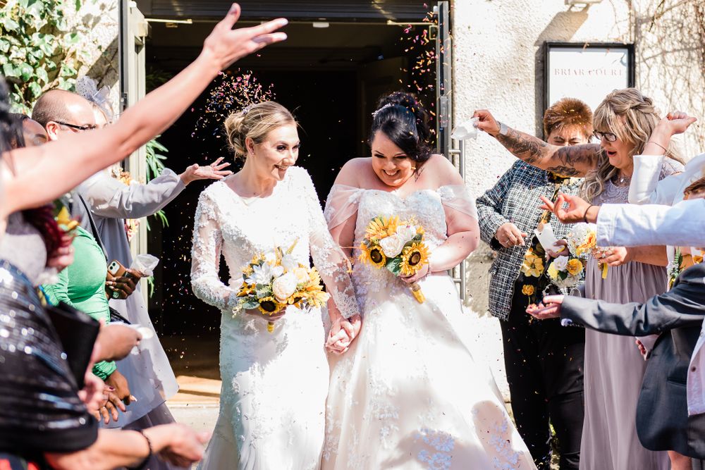 Guests throw confetti on the brides during this lesbian wedding
