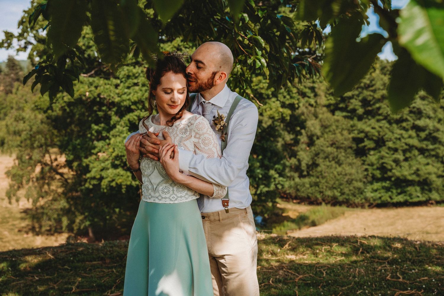 Couple shares intimate moments during outdoor wedding photoshoot in natural garden setting.