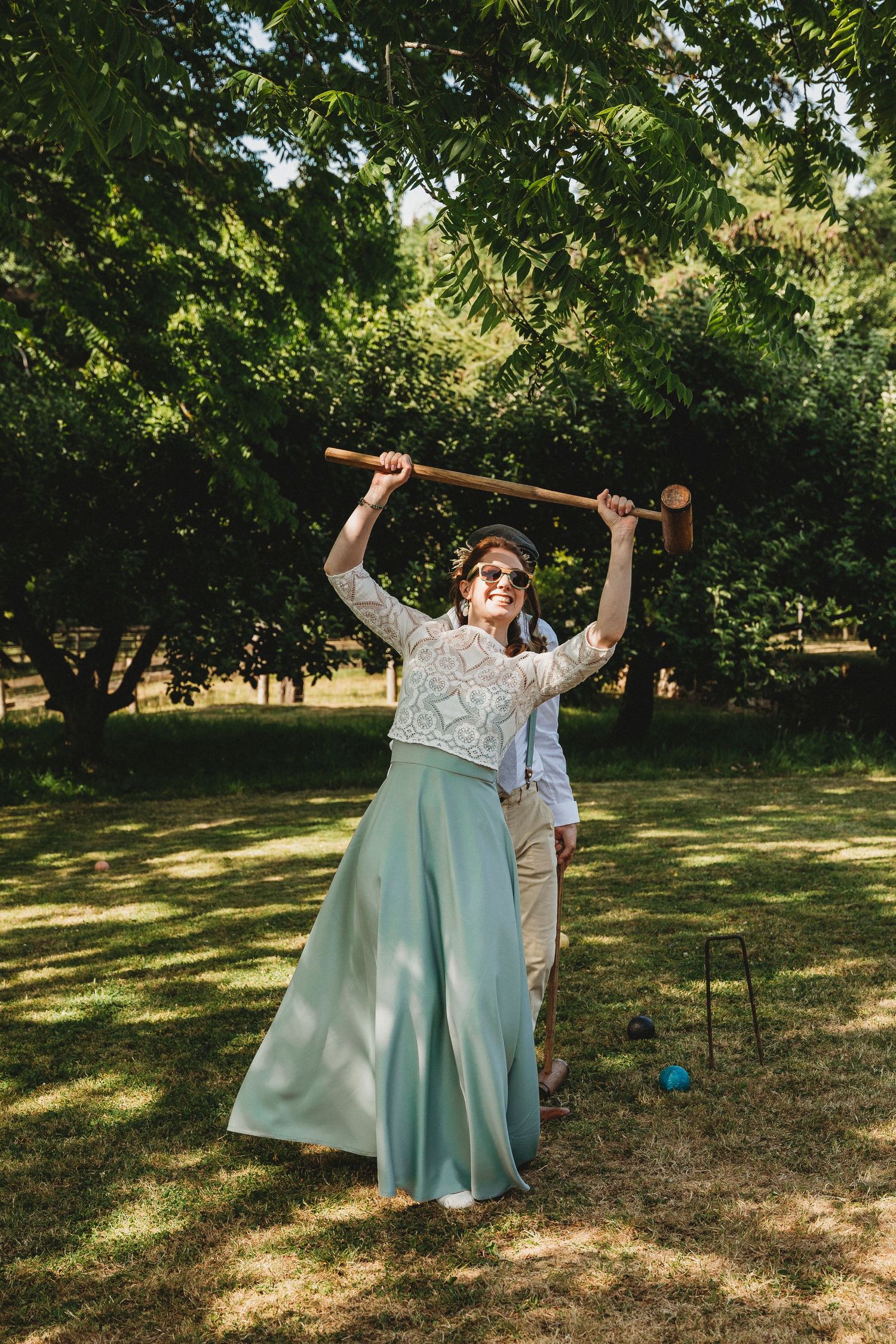 Wedding party playing outdoor games and having fun in garden setting.