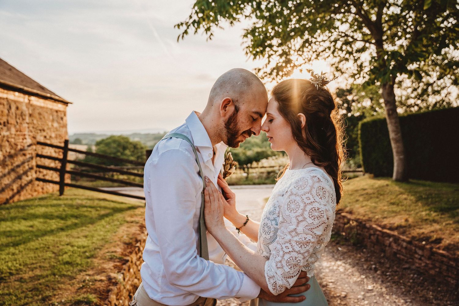 Couple sharing intimate moments along a countryside path during golden hour.
