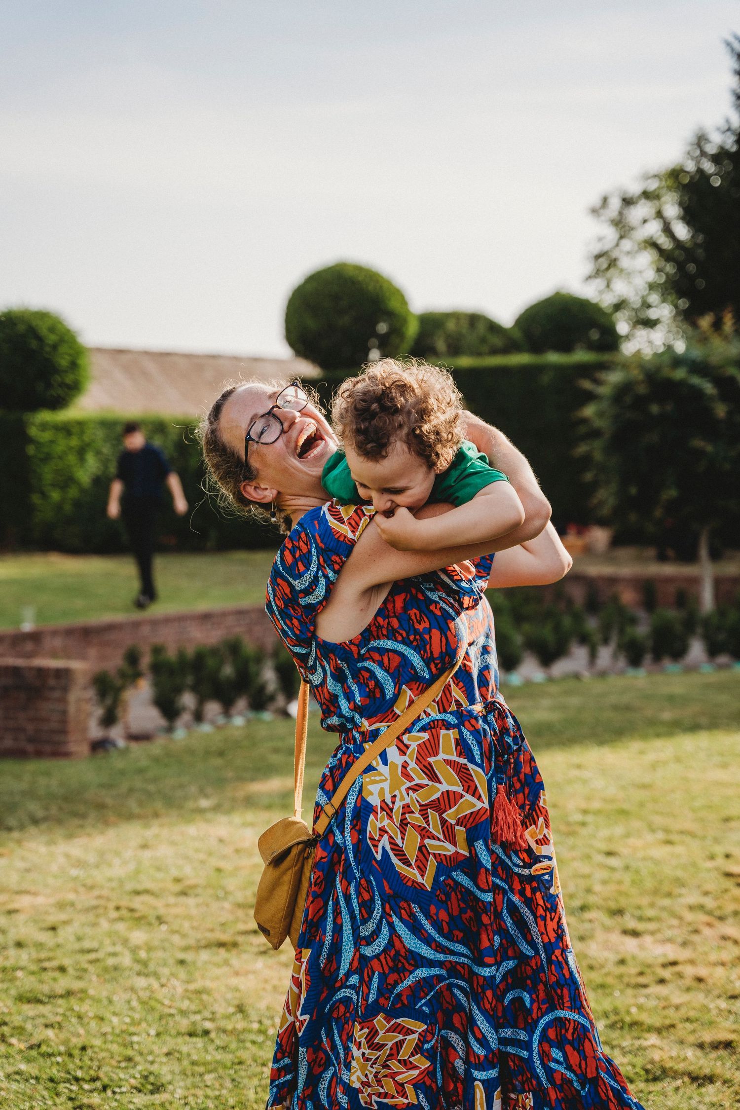 Candid moments of joy and laughter shared between guests in colorful attire outdoors.