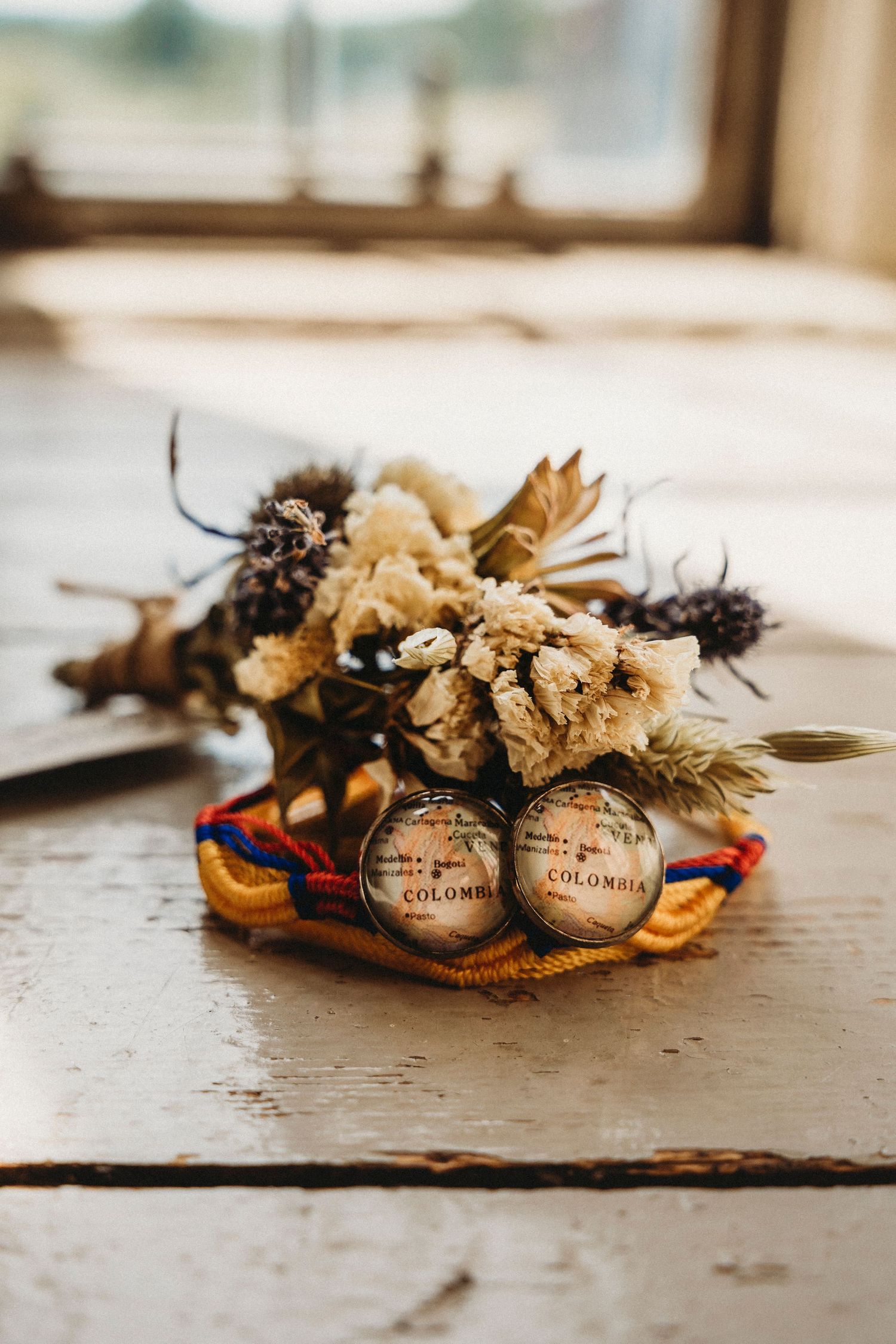 Dried flowers and decorative elements arranged on a textured surface.