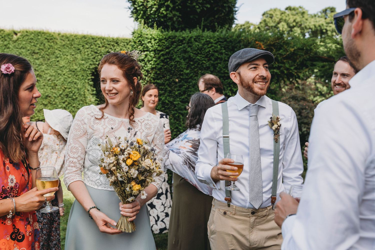 Wedding guests mingling and socializing during outdoor summer celebration.