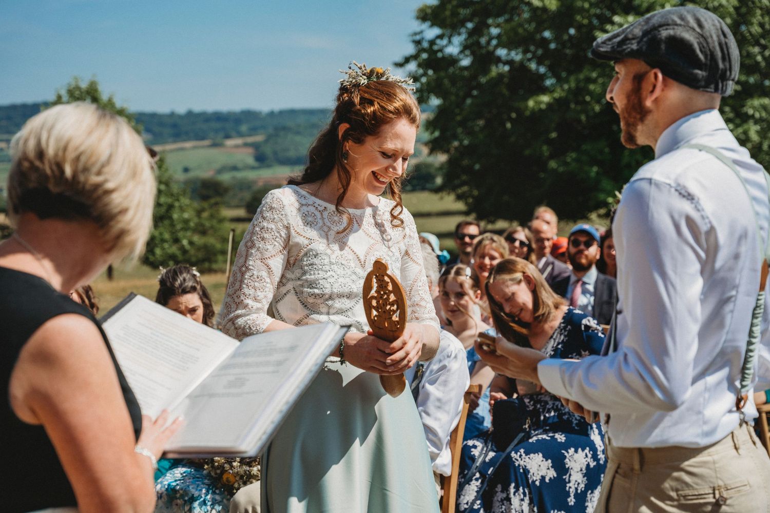 Wedding guests gathered outdoors for celebration on sunny summer day.