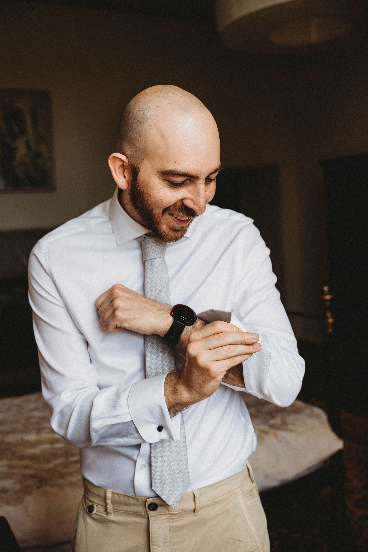 Person in white dress shirt and khakis adjusting their attire.