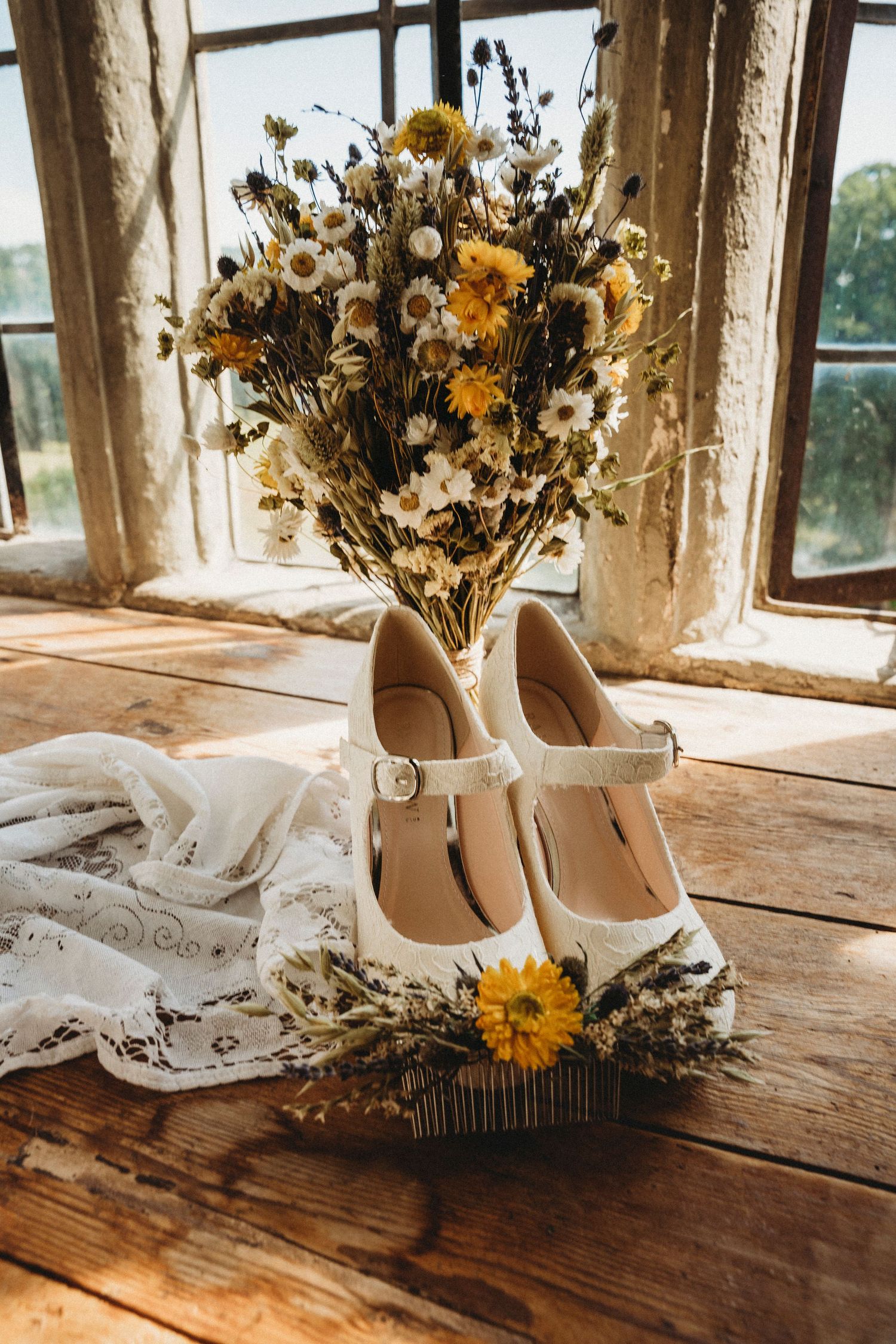 Rustic wedding details with sunflower arrangements and bridal accessories on wooden windowsill.