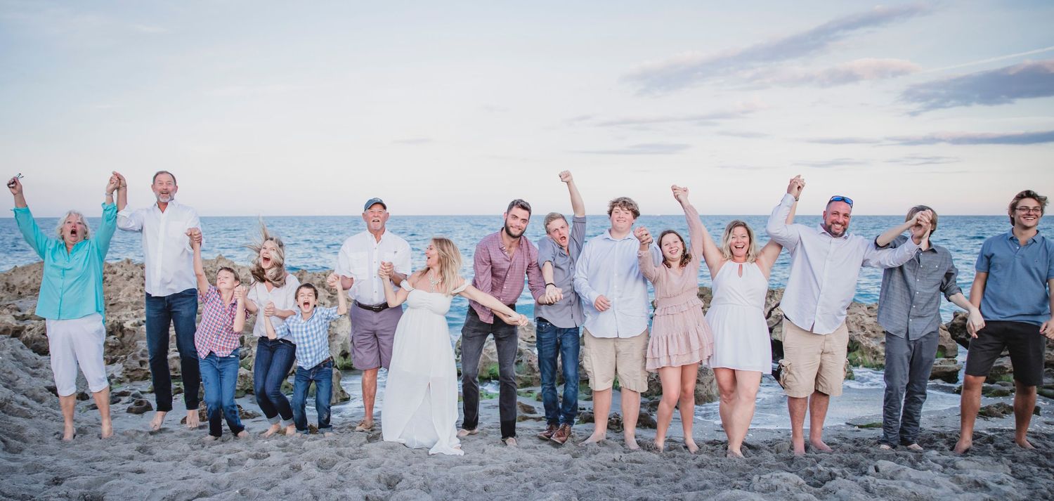 Large extended family cheering together on the beach at Blowing Rocks Preserve on Jupiter Island