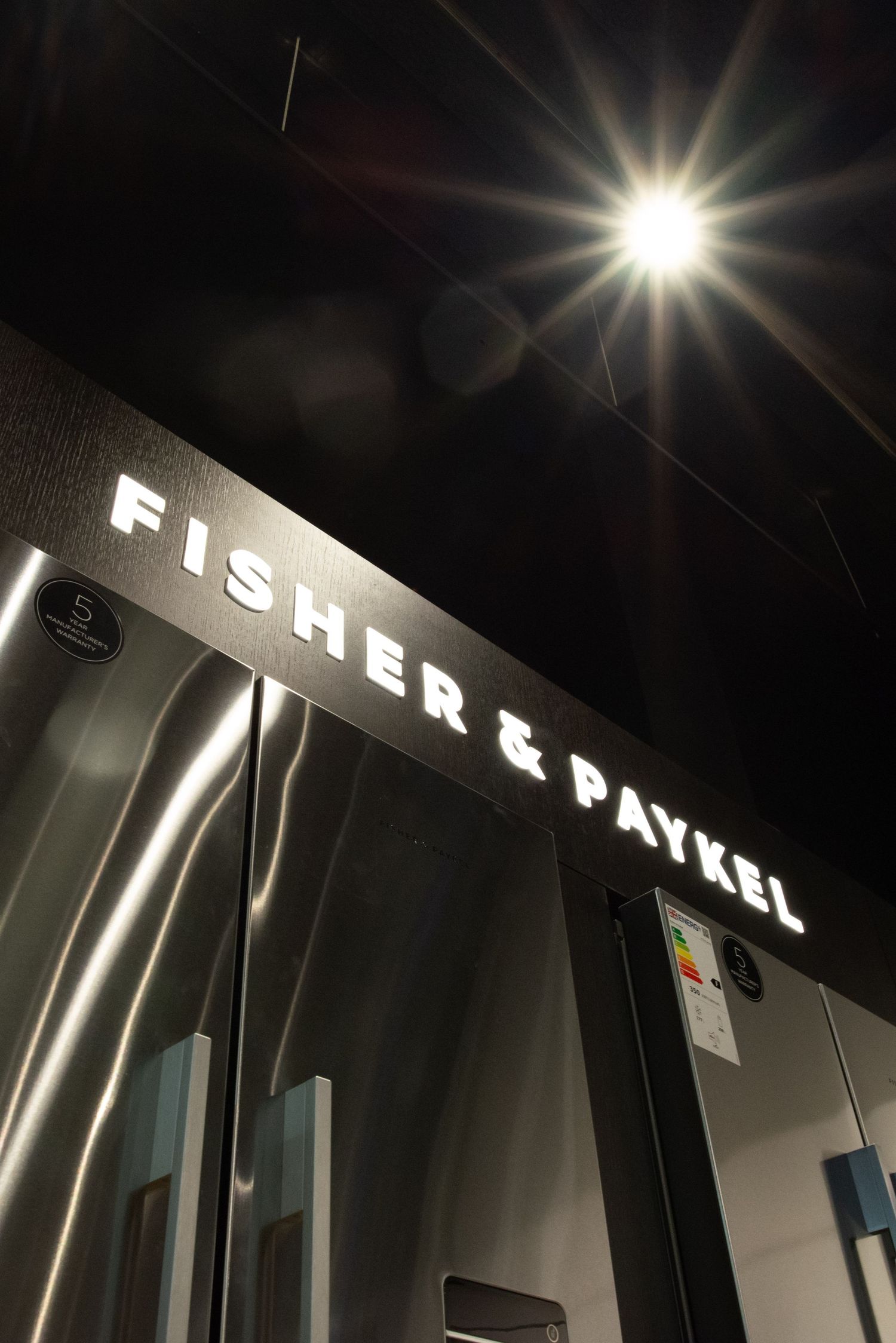 shop fitting for luxury kitchen appliances, dark background with a spotlight flare.