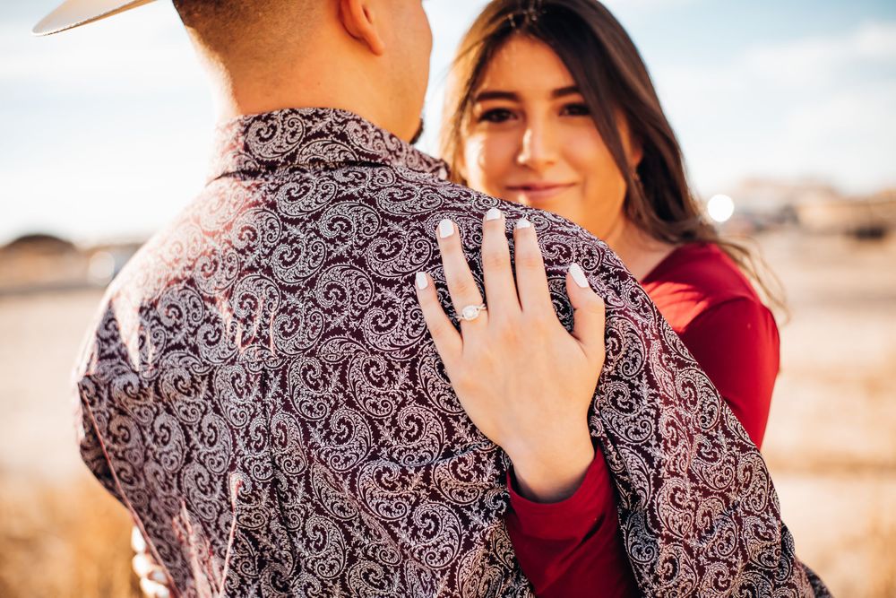 Couple in matching burgundy and paisley print clothing share an intimate moment outdoors.