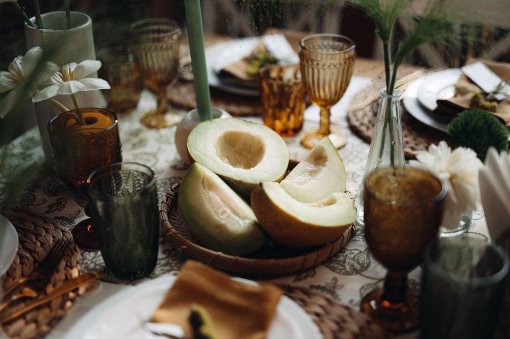 A rustic wedding reception table setting with vintage glassware and ornate place settings.