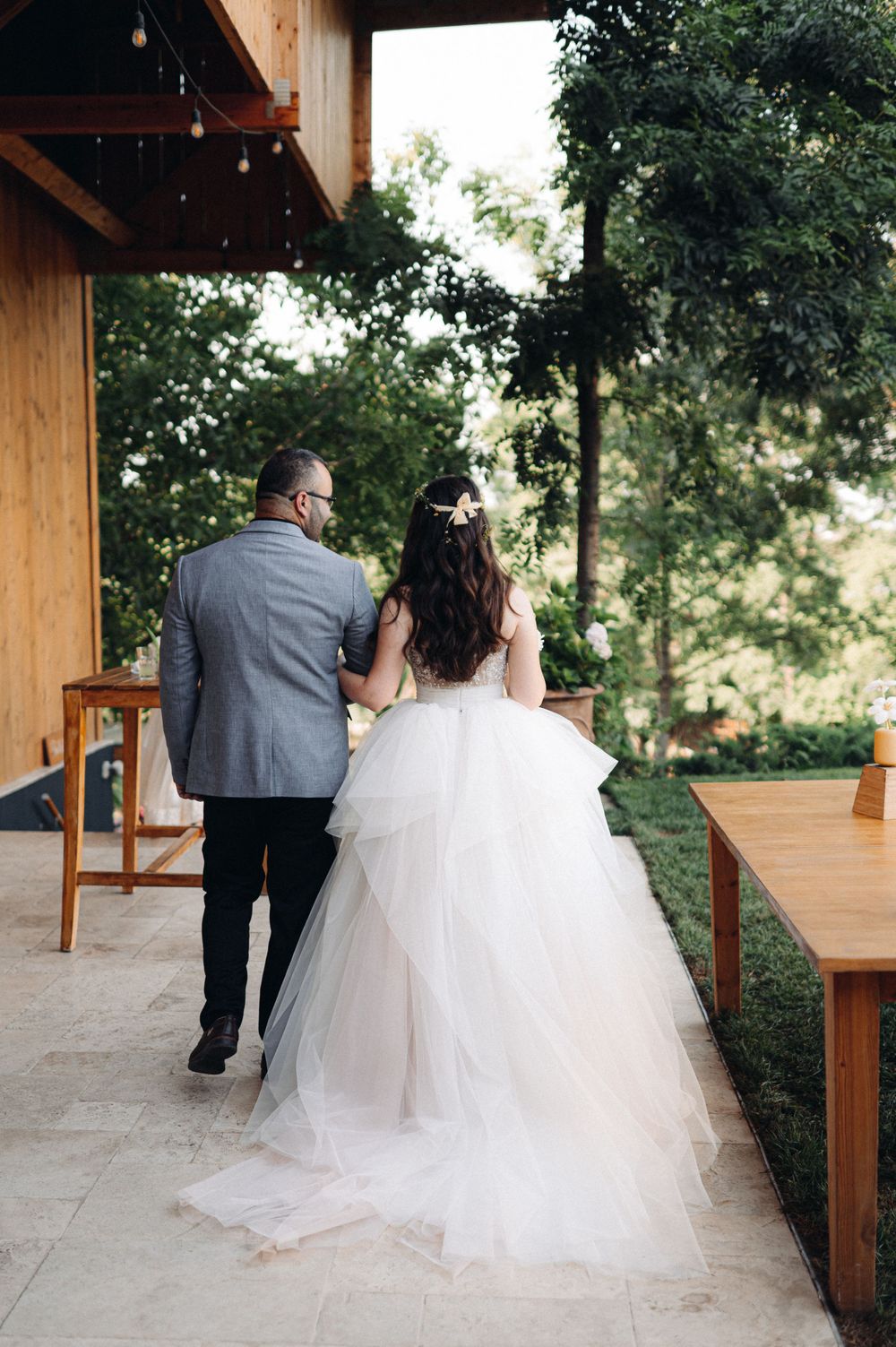 Couple walking together on covered patio during wedding celebration.