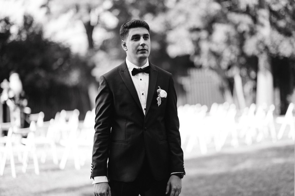 Black and white portrait of formal attire against outdoor background.
