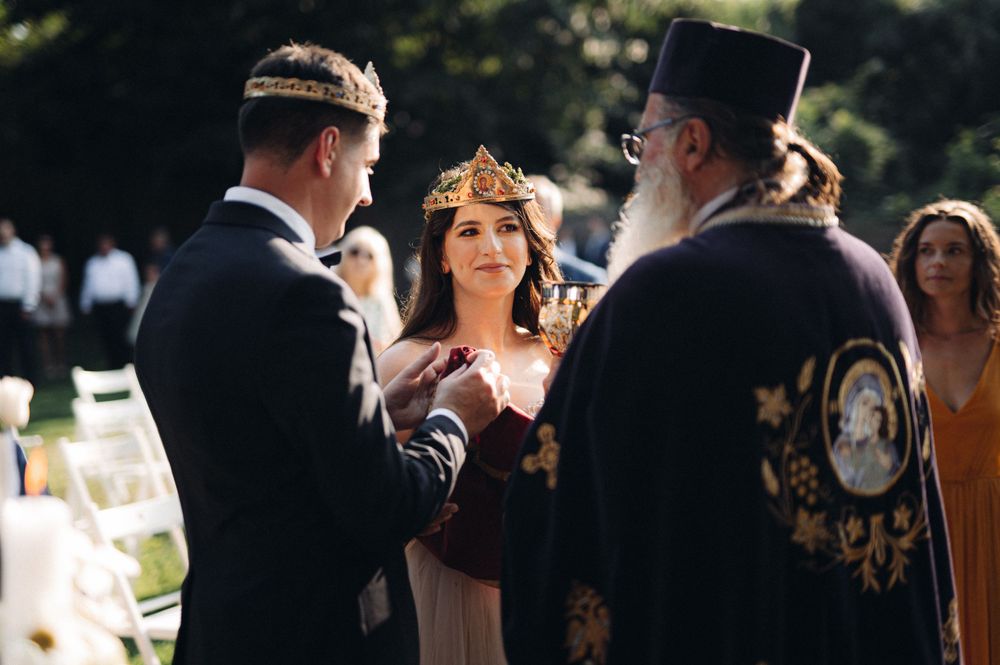 Orthodox wedding ceremony with participants wearing ceremonial crowns and traditional vestments.