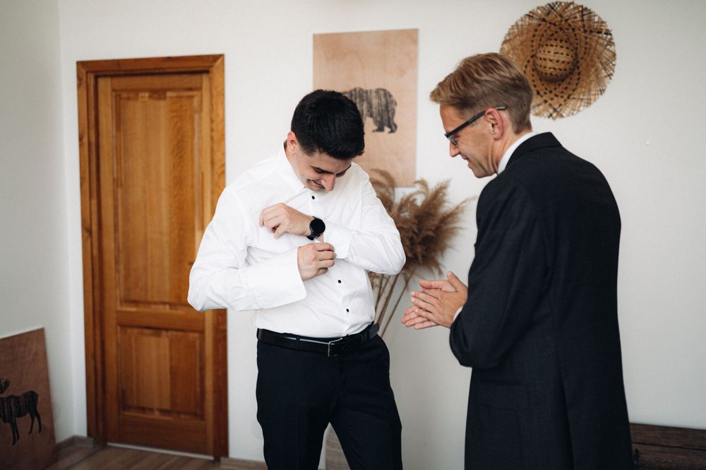 Two people in contrasting formal wear standing in room with minimal decor.