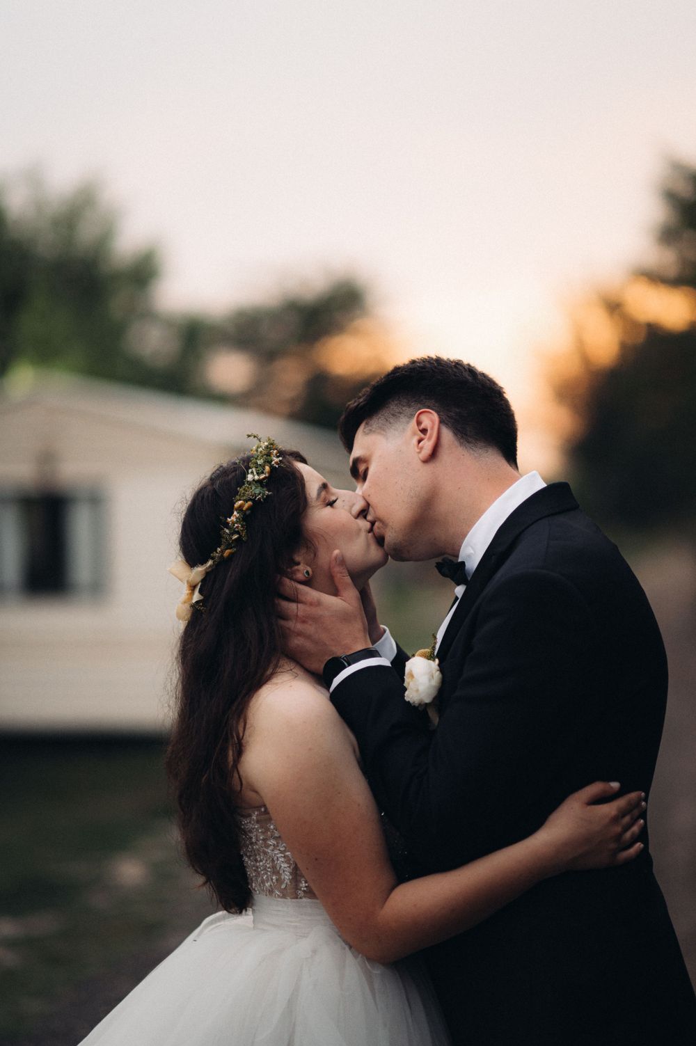 Intimate wedding portrait with sunset and mobile homes in background.