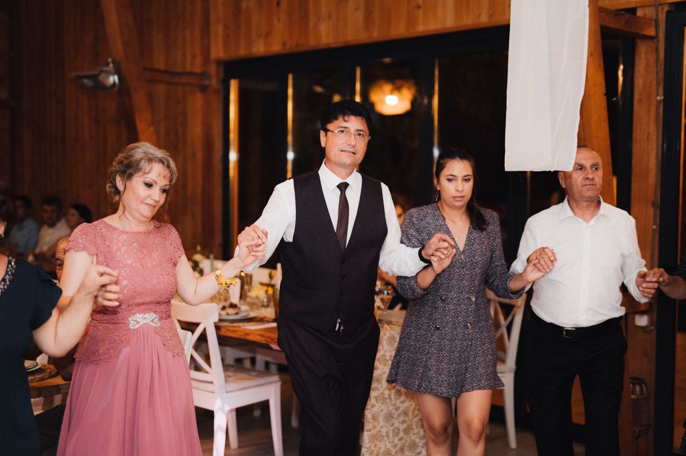 Wedding guests dancing and celebrating in a rustic wooden venue.