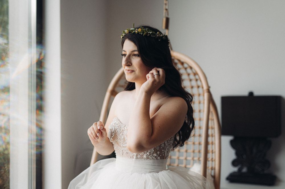 A strapless wedding gown with delicate beading and a crystal headpiece in natural light.