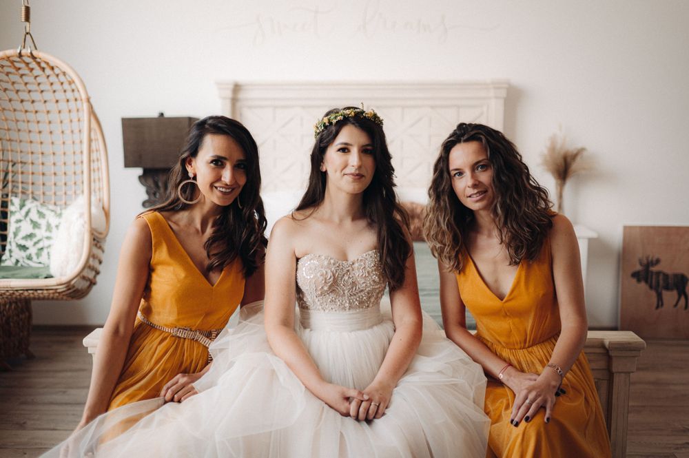 Wedding party portrait featuring mustard yellow bridesmaid dresses and an ornate beaded bridal gown.