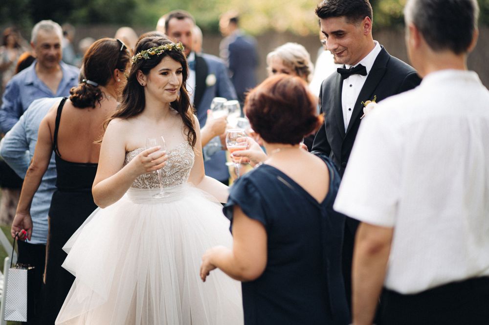 A celebratory outdoor reception gathering with guests enjoying refreshments.