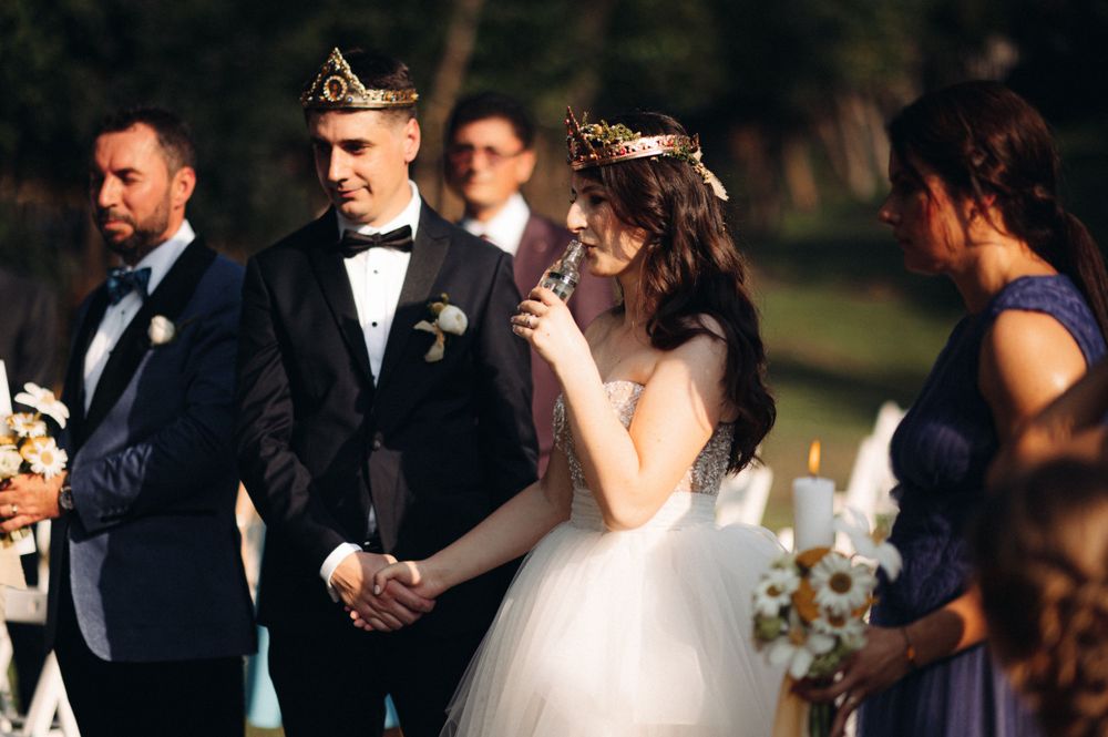 Wedding party standing at altar during outdoor ceremony with bride in white gown.
