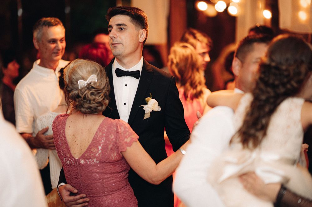 Wedding reception dance floor filled with elegantly dressed guests in formal attire.
