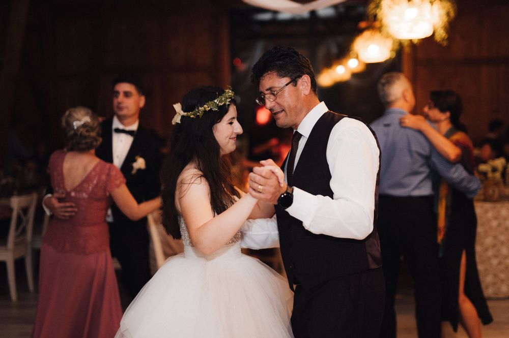 Couples sway on the dance floor at a warmly lit wedding reception.