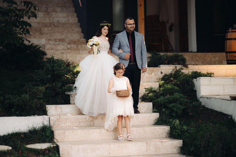 Family members in formal attire descending white stone steps.