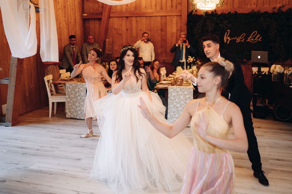 Guests dancing and celebrating at elegant reception in rustic barn venue.