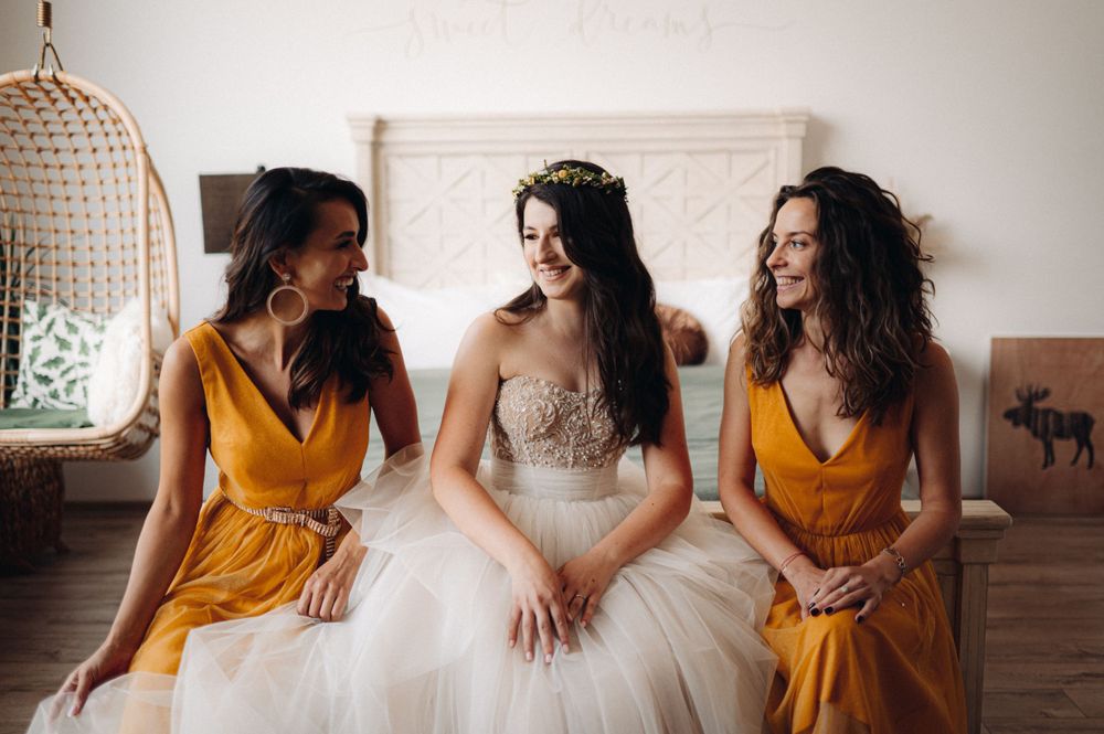 Celebration scene with bridesmaids in mustard dresses alongside bride in beaded wedding gown.