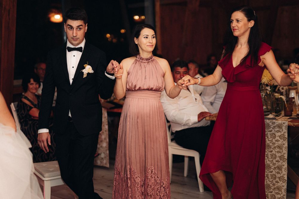 Guests in formal attire dancing at an elegant indoor wedding reception.