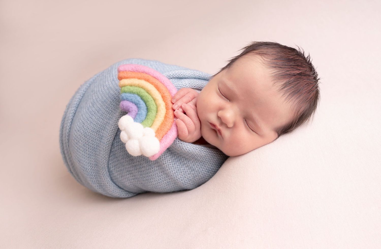 wrapped with meaning, a rainbow baby carefully and peacefully wrapped and posed